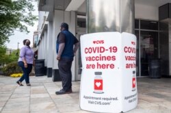 Signs offering COVID-19 vaccinations are seen outside of a CVS pharmacy in Washington on May 7, 2021.