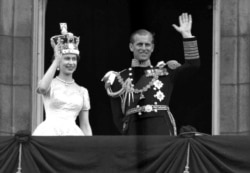 Ratu Inggris Elizabeth II dan suaminya, Duke of Edinburgh, melambaikan tangannya dari balkon Istana Buckingham, London, setelah penobatan Ratu di Westminster Abbey, 2 Juni 1953.