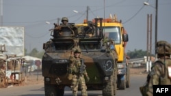 FILE - French soldiers taking part in the operation Sangaris patrol in the PK 12 district in Bangui on December 25, 2013. France announces it will stop military operations in C.A.R. later this year after it's defense minister said its objectives have been achieved.