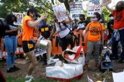 Manifestantes destruyen un pastel de cumpleaños para el presidente Donald Trump, el domingo 14 de junio de 2020, en el parque Lafayette, frente a la Casa Blanca. El presidente cumplía 74 años ese día.