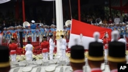 Para pembawa bendera mengibarkan bendera merah putih nasional Indonesia dalam upacara peringatan kemerdekaan di Istana Merdeka di Jakarta, Indonesia, Jumat, 17 Agustus 2018. (Foto: AP)