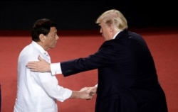 Philippines President Rodrigo Duterte, left, shakes hands with U.S. President Donald Trump during an ASEAN Summit, in Manila, Philippines, Nov. 13, 2017.