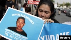 Una mujer muestra el retrato de su hijo desaparecido en México víctima de la violencia.