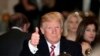 President Donald Trump gives a thumbs-up as he has Thanksgiving Day dinner at his Mar-a-Lago estate in Palm Beach, Fla., Thursday, Nov. 22, 2018. 