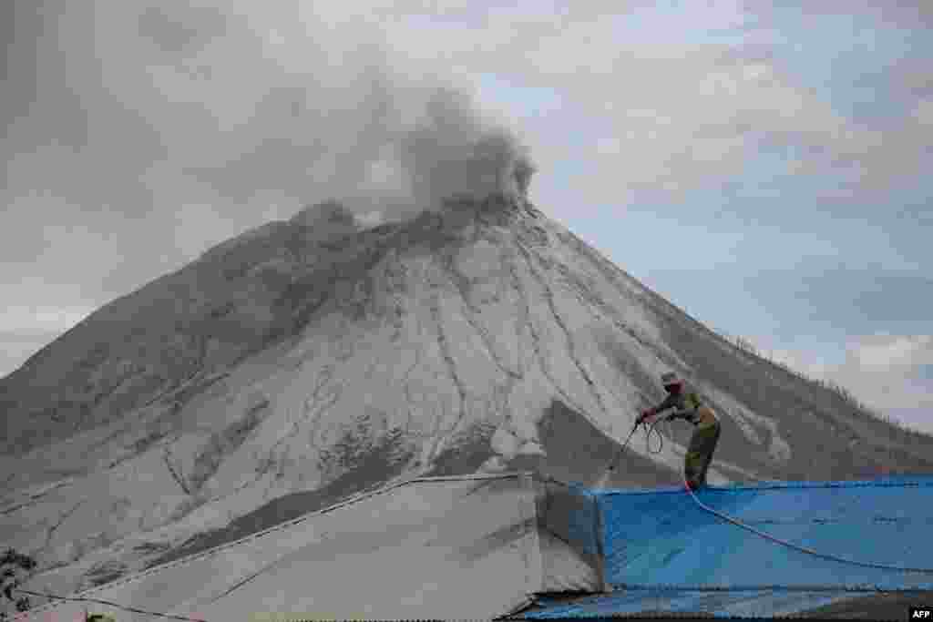 인도네시아 수마트라섬 북부에 위치한 시나붕 화산이 폭발해 재로 뒤덮인 카로 마을에서 주민이 지붕을 치우고 있다. 