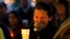 Teresa Welter cries as she holds a candle at a vigil for mudslide victims in Arlington, Washington, March 25, 2014.