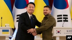 El presidente de Corea del Sur, Yoon Suk Yeol, a la izquierda, y el presidente de Ucrania, Volodymyr Zelenskyy, posan para fotos después de pronunciar declaraciones, el sábado 15 de julio de 2023, en Kiev, Ucrania. (Foto AP/Jae C. Hong)