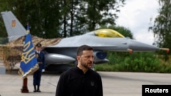 FILE P- Ukraine's President Zelenskiy speaks to the media in a front of an F-16 fighter jet at an undisclosed location in Ukraine, Aug. 4, 2024. 