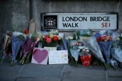 FILE - Tributes are seen at the southern end of London Bridge in London, Dec. 2, 2019, after a man previously convicted of terrorism offenses stabbed two people to death and injured three others before being shot dead by police.