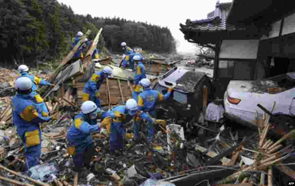 Rescue members seek survivors in Rikuzentakata, northern Japan, Monday, March 14, 2011, three days after a powerful earthquake-triggered tsunami hit the country's east coast. (AP Photo/The Yomiuri Shimbun, Masamine Kawaguchi) JAPAN OUT, MANDATORY CREDIT