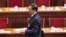 Bo Xilai walks past deserted seats after a plenary session of the National People's Congress in Beijing, China, March 9, 2012.
