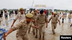 Polisi berjalan di lokasi tempat berkumpulnya jemaat Hindu umat di distrik Hathras di negara bagian utara Uttar Pradesh, India, 3 Juli 2024. REUTERS/Anushree Fadnavis