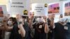 FILE - Supporters of Hong Kong journalist Bao Choy, fined for accessing a public database for an investigative report, hold placards outside a court in Hong Kong, April 22, 2021. 