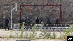 Afghanistan's police officers take positions by nooses prepared to execute men at a jail in Kabul, Afghanistan, Oct. 8, 2014. 