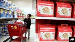 FILE - A shopper looks at an item before placing it in her cart during a trip to a Target store in Edison, N.J., Nov. 16, 2018. 