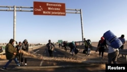 Migrantes indocumentados, en su mayoría de Venezuela, Colombia y Haití, bloquean una carretera en la frontera chilena y peruana mientras permanecen atrapados en Chile el 23 de abril de 2023.