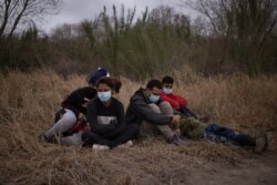 FILE - Asylum-seeking unaccompanied minors from Central America are separated from other migrants by U.S. Border Patrol agents after crossing the Rio Grande river into the United States from Mexico on a raft in Penitas, Texas, March 14, 2021.