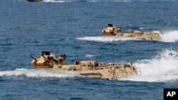 FILE - Philippine and U.S. troops prepare for a combined assault exercise at a beach facing one of the contested islands in the South China Sea known as the Scarborough Shoal in the West Philippine Sea, April 21, 2015.