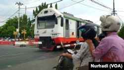 Kereta melintas di palang pintu Lempuyangan, Yogyakarta, Rabu 1 April 2020. Moda transportasi ini biasanya menjadi pilihan pemudik. (Foto: VOA/Nurhadi)