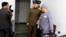 American missionary Kenneth Bae (R) leaves after speaking to reporters at Pyongyang Friendship Hospital in Pyongyang, Jan. 20, 2014.