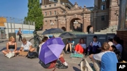 FILE - In this photo taken on Friday, July 26, 2019, teenage climate campaigners sit outside Swedish parliament in Stockholm. 