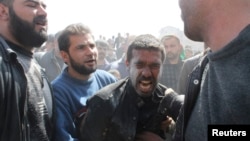 ຊາຍຄົນນຶ່ງຮ້ອງໄຫ້ ນໍາຍາດຄົນນຶ່ງທີ່ເສຍຊີວິດ ໃນອັນທີ່ ພວກເຄື່ອນໄຫວກ່າວວ່າ ເປັນການໂຈມຕີ ໂດຍເຮືອບິນຂອງ ຝ່າຍລັດຖະບານ ຕໍ່ຄຸ້ມ Daiaat Al-Ansari ໃນເມືອງ Aleppo, ວັນທີ 30 ມີນາ 2013.