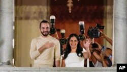 El presidente de El Salvador, Nayib Bukele (izquierda), acompañado por su esposa Gabriela Rodríguez, saluda a sus partidarios desde el balcón del palacio presidencial en San Salvador, El Salvador, después del cierre de las urnas el 4 de febrero de 2024.