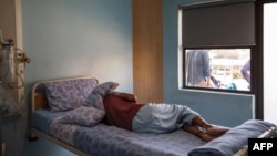 FILE - A TB patient sleeps in his room at the Sizwe Tropical Diseases Hospital in Johannesburg, South Africa, August 5, 2019. 