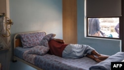 FILE - A TB patient sleeps in his room at the Sizwe Tropical Diseases Hospital in Johannesburg, South Africa, August 5, 2019. 