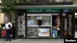 FILE - A man reads a newspaper near a kiosk in Baku, Azerbaijan, June 15, 2015. The Committee to Protect Journalists reported in early January 2025 that Azerbaijan was detaining at least 18 journalists for their work.