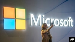 FILE - A visitor takes a photo at the Microsoft stand at Mobile World Congress 2024 in Barcelona, Spain, Feb. 27, 2024. New European Union rules aimed at preventing tech companies from dominating digital markets will change what people see online starting March 7, 2024.