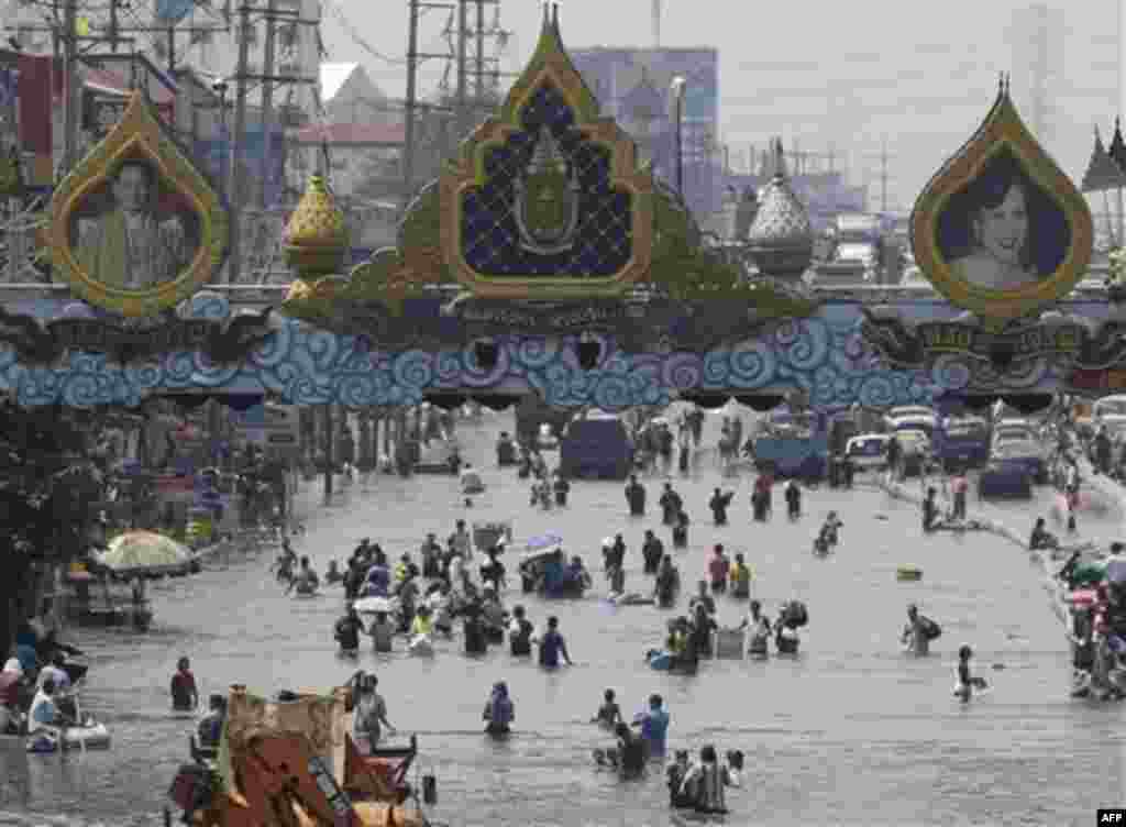 Resident wade through floods in Rangsit district on the outskirts of Bangkok, Thailand on Friday Oct. 21, 2011. Thailand's prime minister Yingluck Shinawatra urged Bangkok's residents to get ready to move their belongings to higher ground Friday as the co