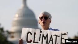 Seorang aktivis lingkungan dalam unjuk rasa untuk menekan politisi AS agar memerangi perubahan iklim, di Washington, 23 September 2020. (Foto: Reuters)