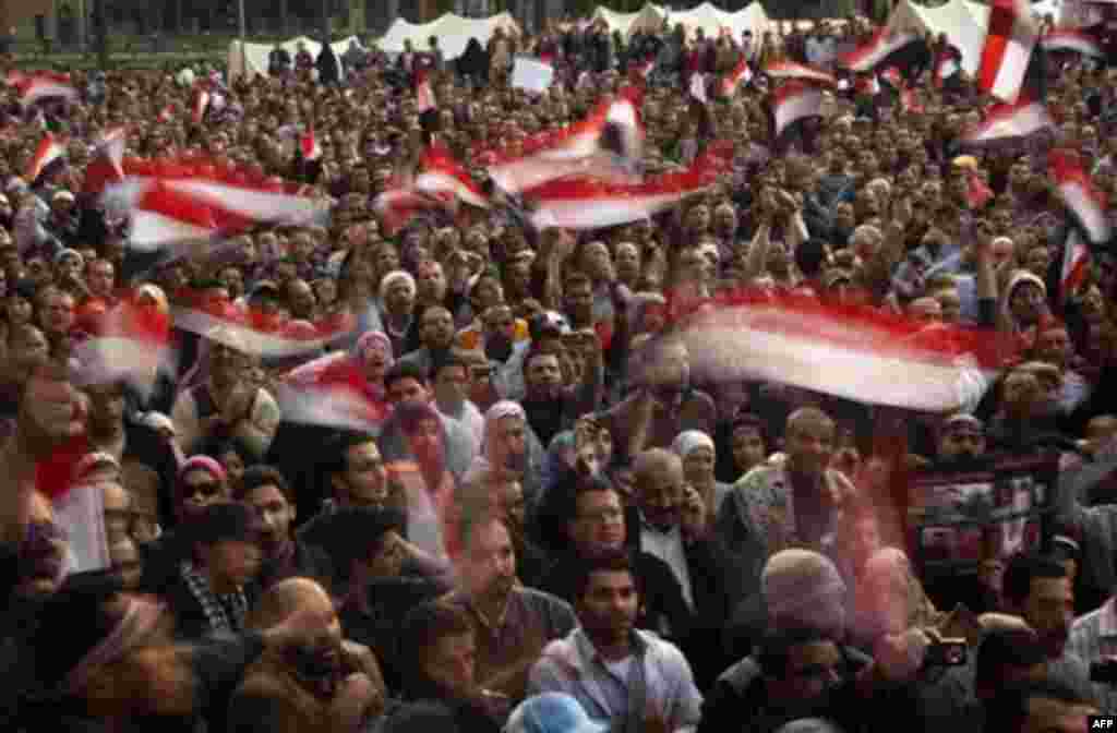 Anti-government protestors hold Egyptian flags during a demonstration at Tahrir Square in Cairo, Egypt, Wednesday, Feb. 9, 2011. Protesters appear to have settled in for a long standoff, turning Tahrir Square into a makeshift village with tens of thousand