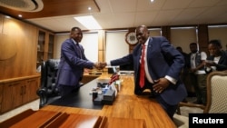 Former President of Botswana Mokgweetsi Masisi, right, hands over his office to newly elected President Duma Boko at the Office of the President, Gaborone, Botswana, Nov. 4, 2024. 