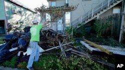Caleb Cormier remueve escombros dejados por el huracán Delta en Lake Charles, Luisiana. El huracán azotó el estado con categoría 2. Sábado 10 de octubre de 2020.