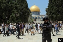 Seorang polisi Israel berjaga-jaga saat pria Yahudi mengunjungi Masjid Kubah Batu di kompleks Masjid Al Aqsa, selama ritual berkabung tahunan Tisha B'Av, di Kota Tua Yerusalem, 18 Juli 2021.