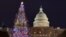 (FILE) People walk by the Capitol West Lawn Christmas tree in Washington, as the US capital prepares for Christmas on December 7, 2024.