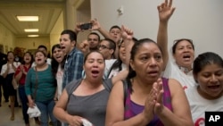 People shout out against the Strengthen and Fortify Enforcement Act in the hall outside the House Judiciary Committee hearing on Capitol Hill in Washington, June 18, 2013. 