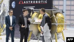 Seorang pejabat Badan Antariksa AS berbincang dengan pejabat Astrobotic Technology tentang wahana pendaratan di Bulan, di Goddard Space Flight Center, di Maryland, 31 Mei 2019. (Foto: NASA)