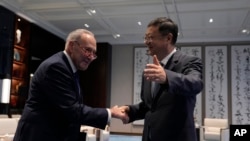 El líder de la mayoría del Senado de Estados Unidos, Chuck Schumer, izquierda, le da la mano al secretario del Partido de Shanghai, Chen Jining, antes de su reunión, en Shanghai, China, el sábado 7 de octubre de 2023. (Aly Song/Pool Photo vía AP)