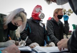 FILE - Opposition supporters wearing protective masks amid the coronavirus disease outbreak put signatures in support of potential candidate Nikolay Kozlov for the upcoming presidential election, in Minsk, Belarus, June 14, 2020.