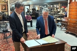 Auctioneer Andrew Brunk, left, and historian Seth Kaller view a 1787 copy of the U.S. Constitution that will be put up for auction on Sept. 28, 2024, at Brunk Auctions in Asheville, N.C., on Sept. 5.