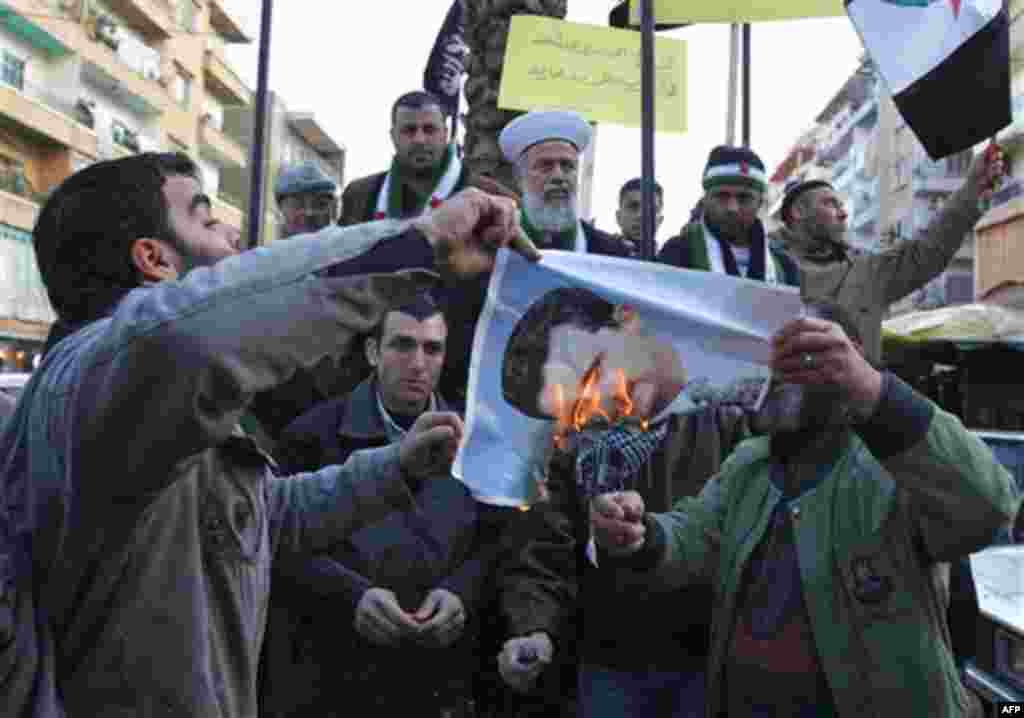 Lebanese anti-Syrian regime protesters, burn a portrait of Syrian President Bashar Assad during a demonstration to show their solidarity with the Syrian people, in the northern city of Tripoli, Lebanon, on Friday Jan. 20, 2102. The Arab League is likely t