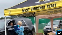 Parents and students arrive in their vehicles for health screenings and temperature checks before moving belongings into residence halls at West Virginia State University campus Friday, July 31, 2020.