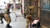 Soldiers beat a supporter of the opposition Movement for Democratic Change party of Nelson Chamisa outside the party's headquarters as they await the results of the general elections in Harare, Zimbabwe, Aug. 1, 2018.