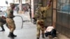 Soldiers beat a supporter of the opposition Movement for Democratic Change party of Nelson Chamisa outside the party's headquarters as they await the results of the general elections in Harare, Zimbabwe, Aug. 1, 2018.