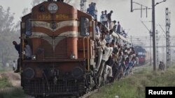 FILE - Passengers travel on an overcrowded train at Loni town in the northern Indian state of Uttar Pradesh. Accidents are common on India's railroad network.