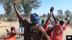 A rioter wearing a police helmet taken from a police officer joins angry protestors in Harare, Monday, July, 4, 2016. (AP Photo/Tsvangirayi Mukwazhi)