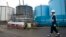  FILE - An employee walks past storage tanks for contaminated water at the tsunami-crippled Fukushima Dai-ichi nuclear power plant of the Tokyo Electric Power Co. in Okuma town, Fukushima prefecture, Japan, Feb. 23, 2017.